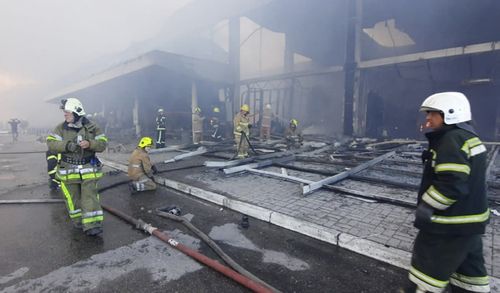 In this image made from video provided by Ukrainian State Emergency Service, firefighters work to extinguish a fire at a shopping center burned after a rocket attack in Kremenchuk, Ukraine, Monday, June 27, 2022. (Ukrainian State Emergency Service via AP)