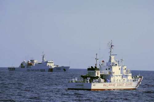 In this photo provided by the Philippine Coast Guard, a Chinese Coast Guard ship sails near a Philippine Coast Guard vessel during its patrol at Bajo de Masinloc, 124 nautical miles west of Zambales province, northwestern Philippines on March 2, 2022.  