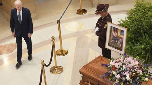 Former President Joe Biden makes a sign of the cross as he pays his final respects to former Minnesota House Speaker Melissa Hortman, her husband, Mark, and their golden retriever, Gilbert