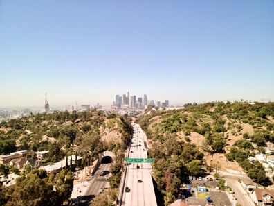 Los Angeles skyline in the background and a freeway in the foreground