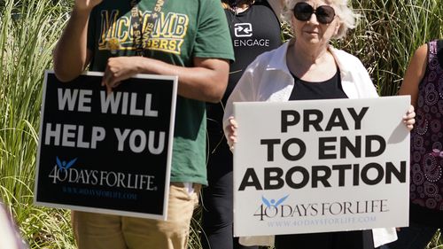 A clinic escort holds an abortion rights poster as an anti-abortion protest takes place outside the Jackson Womens Health Organisation clinic in Jackson, Mississippi. 