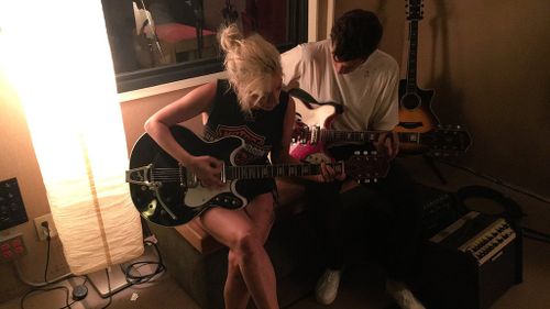 Gaga playing guitar alongside Mark Ronson. (Twitter: @ladygaga)
