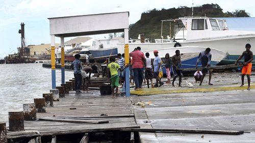 People recover broken parts of the dock after the passing of Hurricane Irma, in St. John's. (AAP)