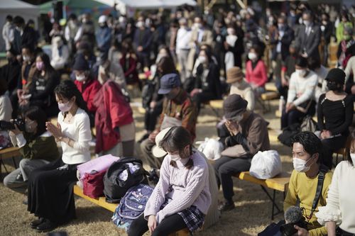 Visitors pray for a minute of silence for the victims of the March 11, 2011 earthquake and tsunami during a special memorial event Friday, March 11, 2022, in Tokyo, Japan