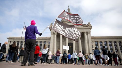 A person holds a pro-choice for women flag at a Bans Off Oklahoma Rally. 