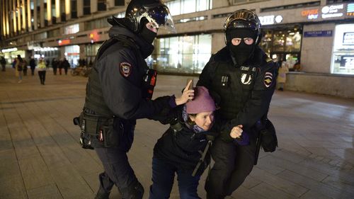 Police officers detain a woman in Moscow, Russia.
