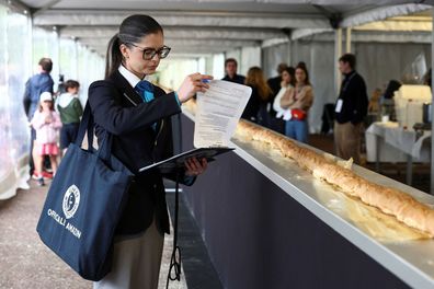 Joanne Brent, adjudicator of the Guinness World Records stands near the baguette during her inspection of the attempt.