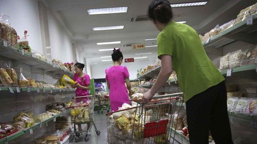 Staff at the Potonggang department store stock shelves with local and imported snacks. (AAP)