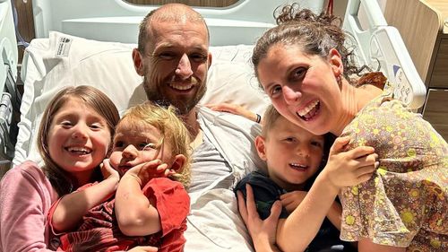 Michael Lindquist, pictured after he was flown back to Coffs Harbour Base Hospital on Tuesday with his wife Zanna and children (from left to right) Scarlett, Benji, and Tommy. 
