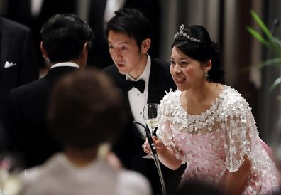 Japan's former princess Ayako Moriya (R) and her husband Kei Moriya (C) toast with Crown Prince Naruhito at their wedding banquet in Tokyo, Japan, October 28, 2018.  