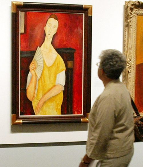 A visitor looks at "La Femme à l'éventail" (Woman with a Fan) by Amedeo Modigliani during an exhibition at The Jewish Museum in New York. Source: AFP