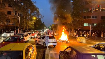 A police motorcycle burns during a protest over the death of Mahsa Amini, a woman who died after being arrested by the Islamic republic&#x27;s &quot;morality police&quot;, in Tehran, Iran September 19, 2022.  