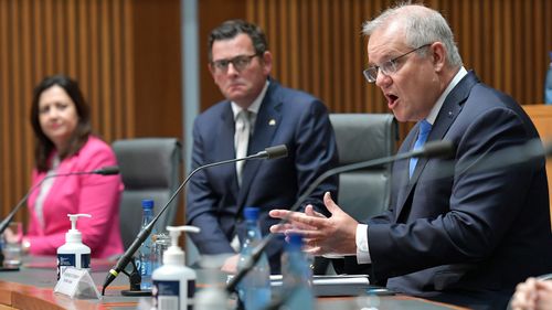 Australian Prime Minister Scott Morrison speaks with state premiers Annastacia Palaszczuk and Daniel Andrews at a National Cabinet meeting.