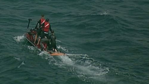 Lifeguards on jetskis are searching for the shark. (9NEWS)