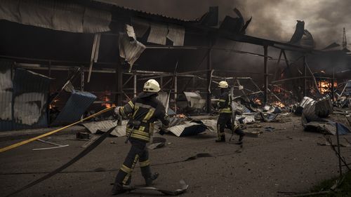 Firefighters work to extinguish a fire on a warehouse amid Russian bombardments in Kharkiv, Ukraine on Saturday, April 23.