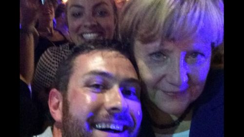 Angela Merkel poses with some lucky drinkers on Caxton Street in Brisbane. (Sarah Keayes)