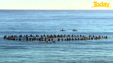 Dozens of Byron Bay locals assembled in the surf to form a 'cancel' symbol. 