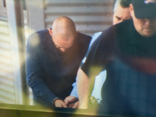 One of the alleged thieves was led away in handcuffs. (9NEWS)