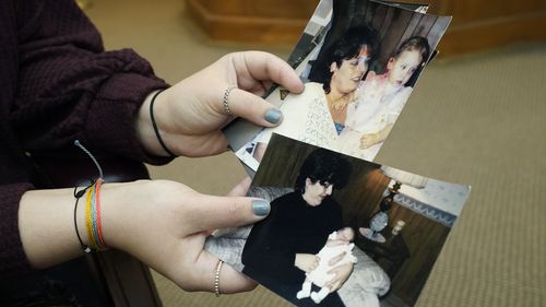 Lindsey Kirk shows childhood photographs of herself and her late mother Kim Kirk Cox.