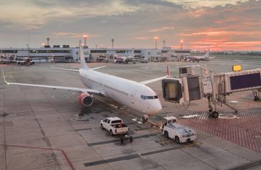 Airplane preparing for takeoff in international airport in morning.Scenic sunrise over airport terminal building.Travel concept