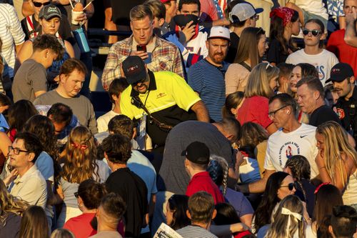 The crowd watches as a member of Provo Fire and Rescue searches for an injured individual after an errant firework exploded among attendees during Stadium of Fire held at LaVell Edwards Stadium in Provo, Utah., on Thursday, July 4, 2024.
