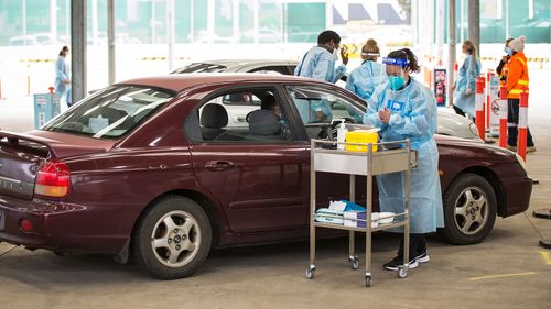 Une infirmière administre le vaccin Pfizer COVID-19 dans un centre de vaccination en voiture à Melton, Melbourne.