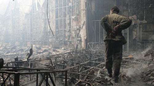 A man stands amidst the devastation after a youth centre was destroyed by shelling in Donetsk. (Photo by Alexander Ermochenko/Anadolu Agency/Getty Images)