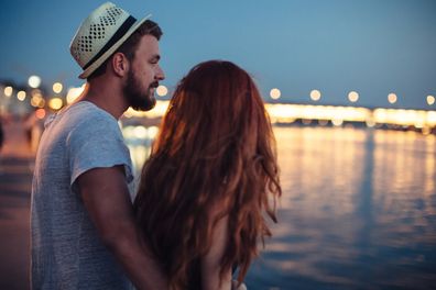 Young couple enjoying in summer night by the river. 