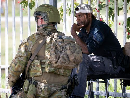 An Australian Army soldier talks with a local police officer in Honiara, Solomon Islands