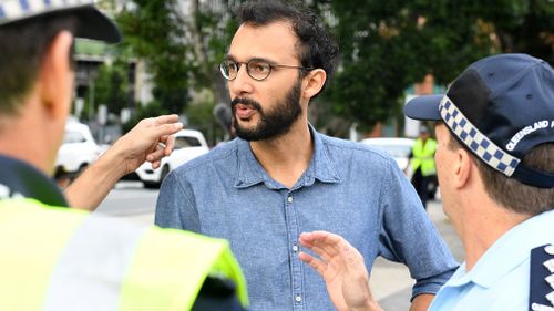 Local councillor Jonathan Sri speaks with police. (AAP)