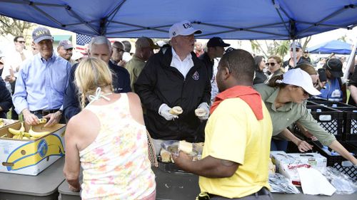 Mr Trump hands out food with Melania Trump's help. (AFP)