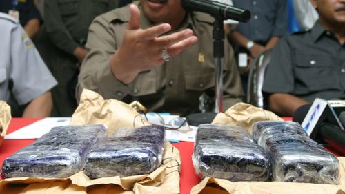 Chairman of Indonesian National Drug bureau Makbul Padmanegara shows the six kilograms of smuggled heroin. (AAP) 