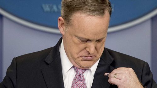 Sean Spicer looks at his lapel pin. (AP)