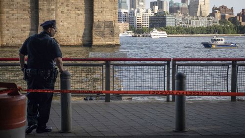 Police at the spot where the baby was found in the New York river.