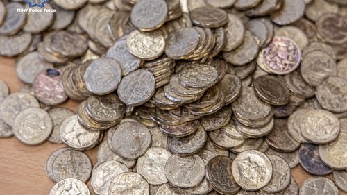 Two people have been charged over an alleged money laundering scheme involving damaged Australian coins.