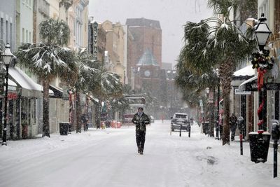 A person walks in the snow on King Street in Charleston, South Carolina.