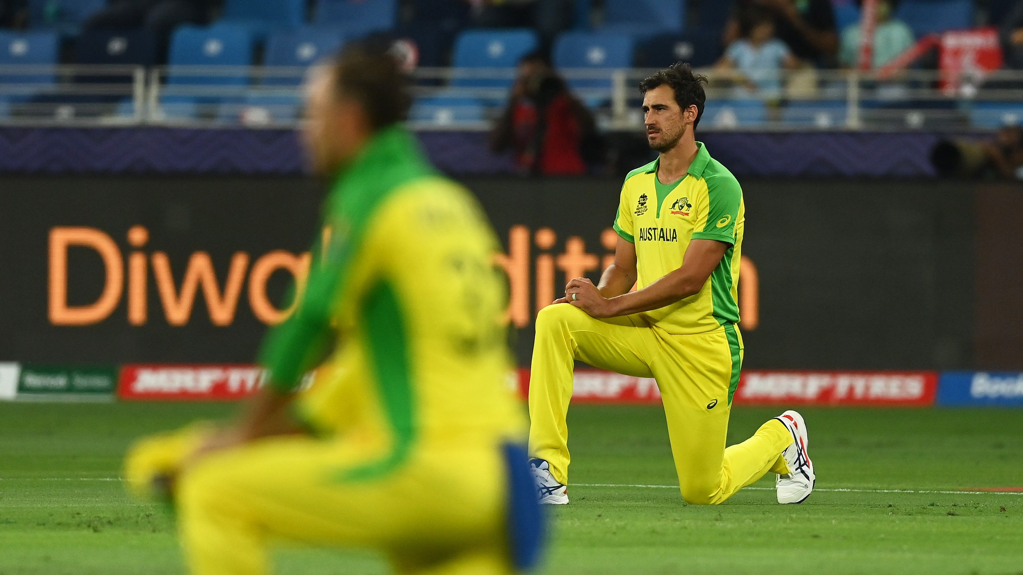 Mitchell Starc takes a knee during the 2021 ICC Men&#x27;s T20 World Cup final match between New Zealand and Australia.