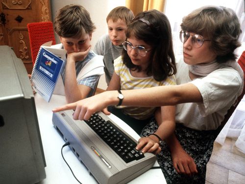 Adolescents try out a Commodore 64 in Nuremberg in May 1985. (Photo by Karl Staedele/picture alliance via Getty Images)