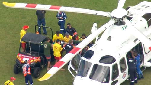 Emergency services transport one of the critically ill fishermen to a rescue helicopter.