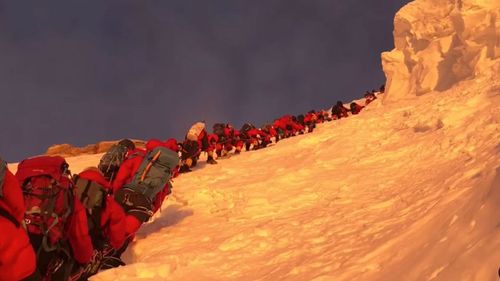 Climbers line up and wait on K2's bottleneck couloir.