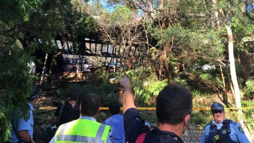 Police and emergency services surround the gutted house. (9NEWS)