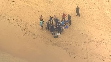 Lifeguards and emergency services performed CPR on the man found lying face down in the water near the centre of the beach