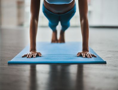 Shot of a woman doing pushups during her workout routine at home.