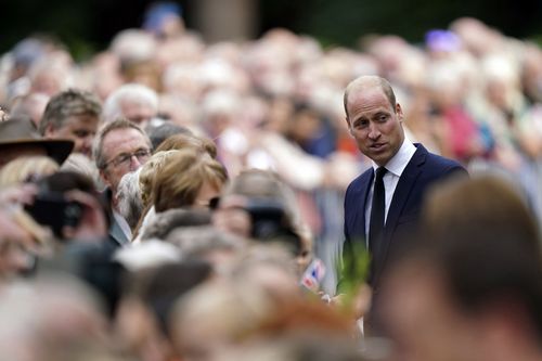 Britain's Prince William meets members of the public after viewing floral tributes to late Queen Elizabeth II at the gates of Sandringham House.