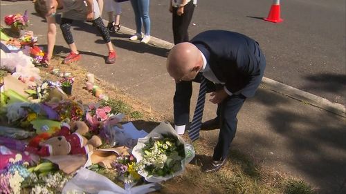 Tasmania Premier Peter Gutwein places flowers at a memorial site