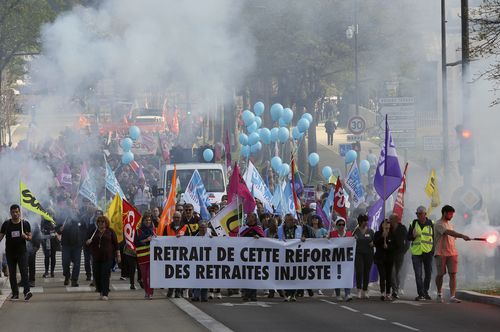 Protesters march during a rally in Bayonne, southwestern France, Thursday, April 6, 2023.  The banner in French reads "Withdraw this unfair pension reform". 