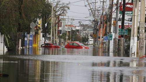 Cars trapped on a flooded street in San Juan. (AAP)