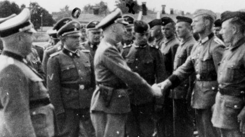 This 1942 photo provided by the United States Holocaust Memorial Museum, shows SS chief Heinrich Himmler, centre left, shaking hands with new guard recruits at the Trawniki concentration camp in Nazi occupied Poland. 