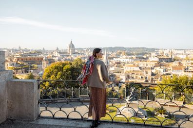 Woman enjoying beautiful morning cityscape of Rome, walking in Villa Borghese Park
