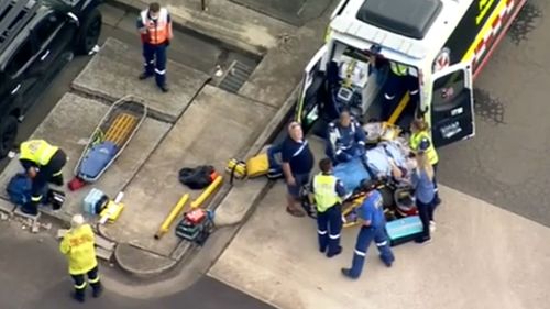 A woman is fighting for life after getting trapped underneath a rolling car.